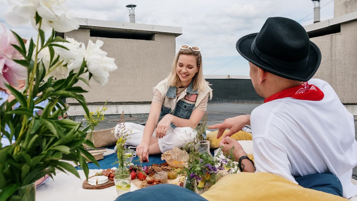 A cheerful group of friends enjoying a summer picnic on a rooftop, capturing leisure and friendship outdoors.
